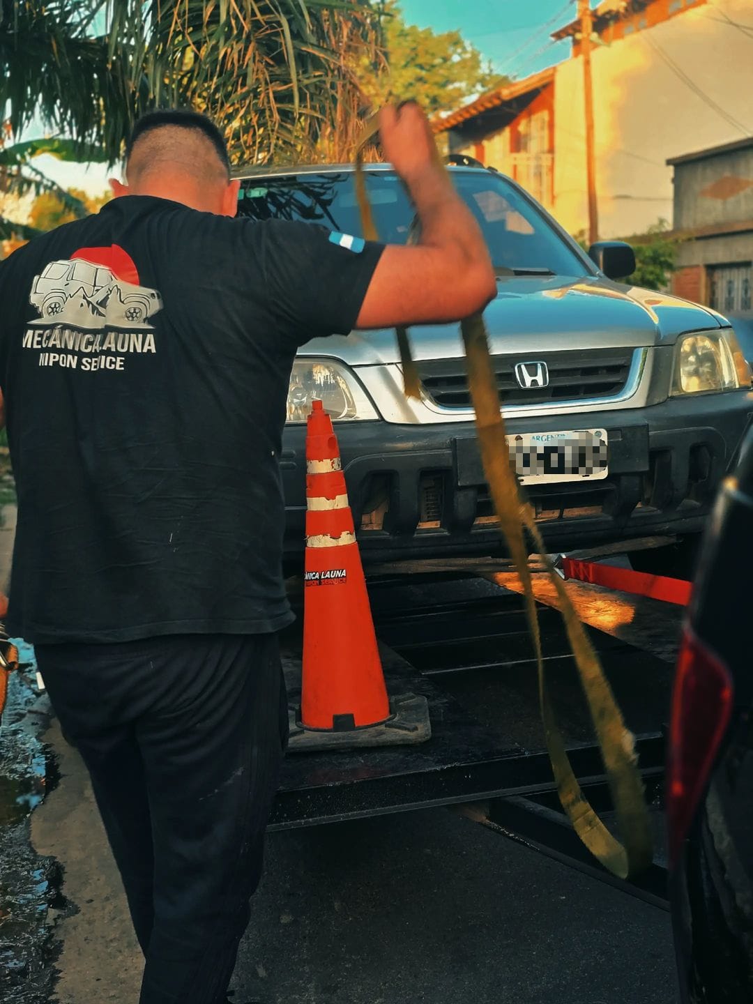 Martín asegurando una Honda sobre el tráiler durante un auxilio real